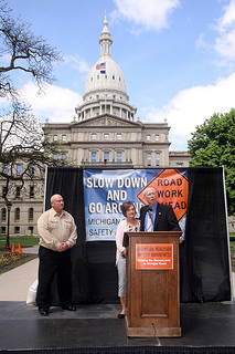 Sen. Bruce Caswell presents a resolution to Robin Creel, widow of Consumers Energy employee Jeff Creel, killed while working along the roadway. Consumers Energy retiree Frank Coolbaugh, left, looks on. Photo-Consumers Energy